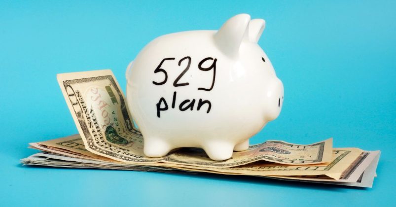 Piggy bank labeled 529 plan sitting on top of cash, symbolizing college savings with CDs