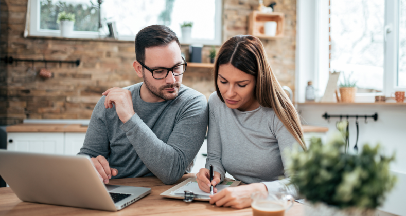 A young man and woman look at Certificate of Deposit paperwork together in an office